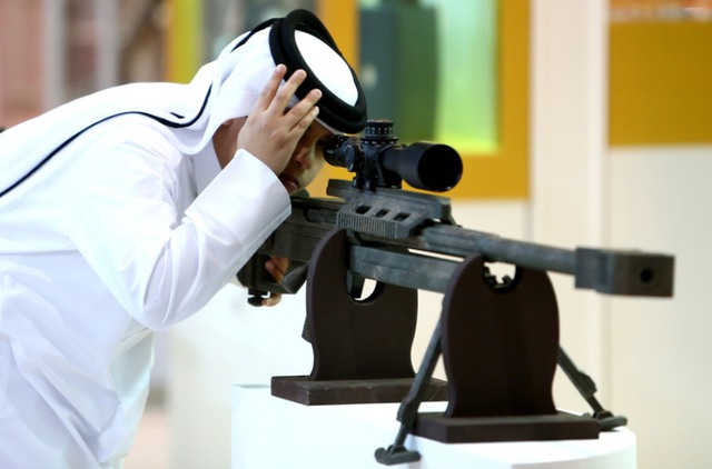 Khách tham quan kiểm tra một khẩu súng bắn tỉa tại triển lãm vũ khí Abu Dhabi 2014, Các tiểu vương quốc Ả-rập thống nhất.