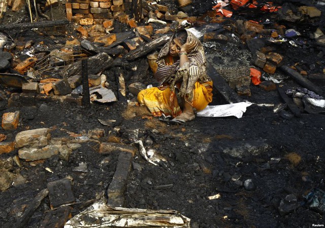 Người phụ nữ ngồi khóc trên nền ngôi nhà bị hỏa hoạn thiêu rụi tại một khu ổ chuột ở Kolkata, Ấn Độ.