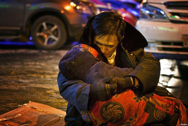 Người đàn ông ôm xác vợ trong đêm lạnh dưới 0 độ C ở thành phố Thẩm Dương, Trung Quốc. Người phụ nữ tử vong do lên cơn đâu tim sau khi mua thuốc tại một quần thuốc.