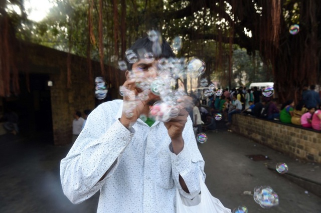 Người đàn ông bán đồ chơi thổi bong bóng cho du khách trước Cổng vào Ấn Độ (Gateway of India) ở thành phố Mumbai.