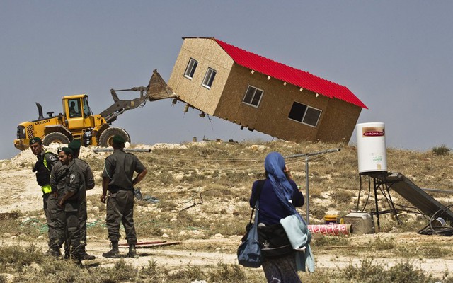 Cảnh sát biên giới Israel đứng cạnh một xe ủi đang phá một ngôi nhà tạm tại khu định cư của người Do Thái ở Maale Rehavam, gần Bethlehem, Bờ Tây.