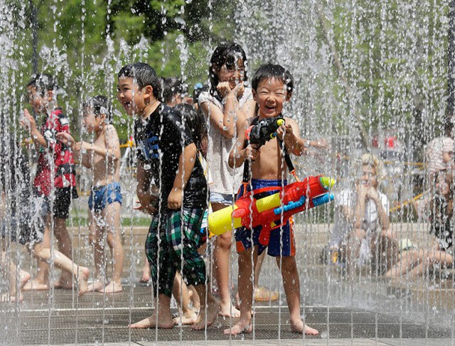 Trẻ em thích thú chơi với nước trong một công viên ở Tokyo, Nhật Bản. Ít nhất 2 người thiệt mạng và hàng trăm người phải nhập viện do nắng nóng ở Nhật Bản.