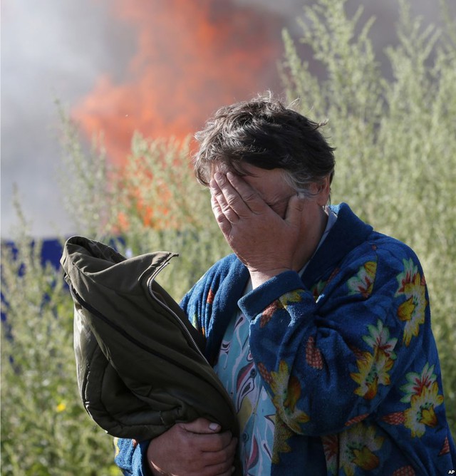 Một nữ đứng khóc trước ngôi nhà bị phá hủy bởi đạn pháo ở thành phố Sloviansk, Ukraine.