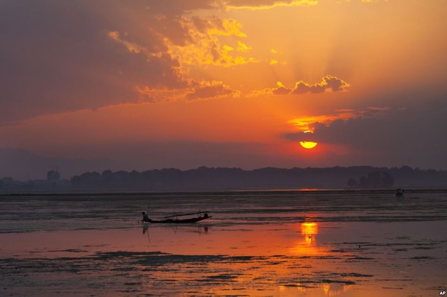 Một ngư dân đánh cá dưới hoàng hôn trên hồ Dal ở Srinagar, Ấn Độ.