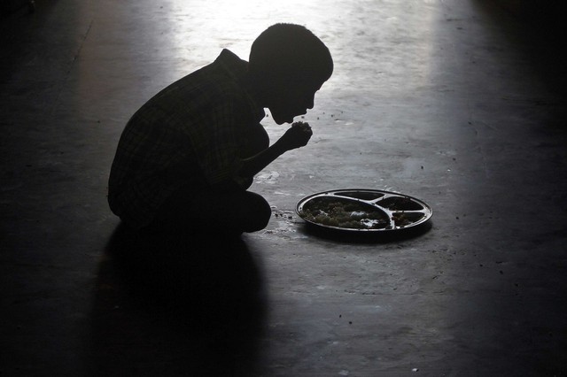 Một cậu bé ngồi ăn tại một trại trẻ mồ côi ở Chennai, Ấn Độ.