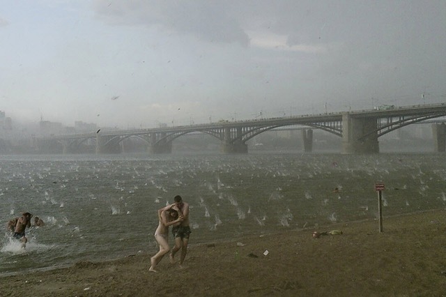 Mọi người chạy tránh mưa đá bất ngờ trên bãi cát trên sông Ob ở Novosibirsk, Nga.