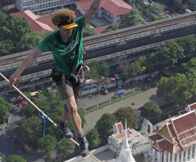 Andy Lewis, đến từ Mỹ, đi thăng bằng trên dây nối giữa hai tòa nhà cao tầng ở Bangkok, Thái Lan.