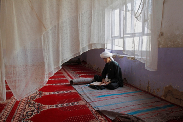 Cậu bé theo đạo Hồi ngồi đọc kinh Quran trong một nhà thờ ở Kandahar, Afghanistan.