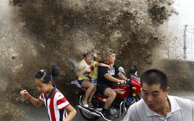 Mọi người chạy tránh sóng đánh vào bờ khi thủy triều dâng trên sông Qiantang ở Hàng Châu, Trung Quốc.