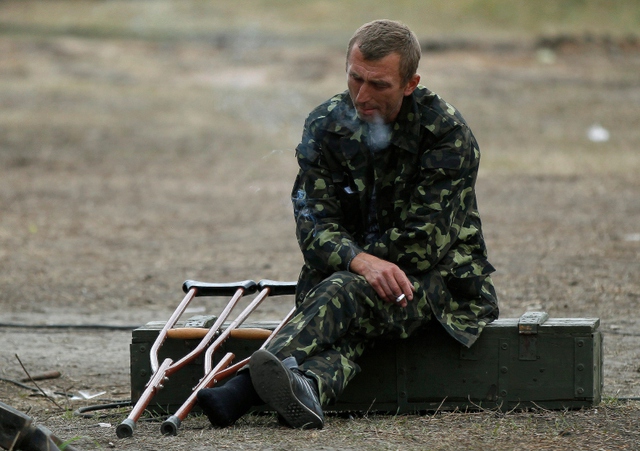 Binh sĩ bị thương ngồi hút thuốc ở Svatove, Ukraine.