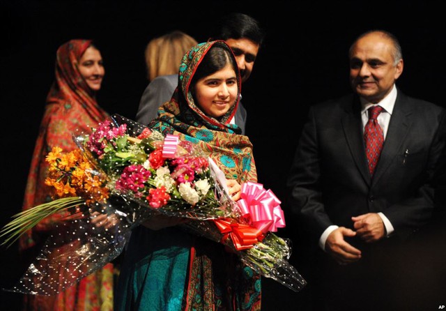 Bé gái Malala Yousafzai ôm hoa tại cuộc họp báo ở thư viện Birmingham, Anh, sau khi vinh dự được nhân giải Nobel Hòa bình.