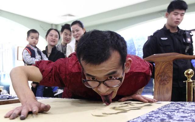 Nghệ sĩ Han Xiaoming trình diễn vẽ tranh bằng lưỡi trước một nhóm du khách ở Hàng Châu, Trung Quốc.