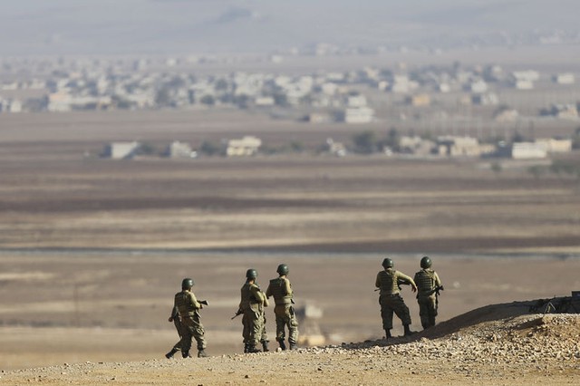 Binh sĩ Thổ Nhĩ Kỳ đứng trên đình đồi ở tỉnh Sanliurfa của nước này, quan sát cuộc giao tranh giữa chiến binh người Kurd và nhóm phiến quân Nhà nước Hồi giáo ở thị trấn Kobani, Syria.