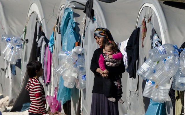 Một phụ nữ tị nạn đến từ thị trấn Kobani, Syria, bế con nhỏ tại trại tị nạn ở tỉnh Suruc, Thổ Nhĩ Kỳ.