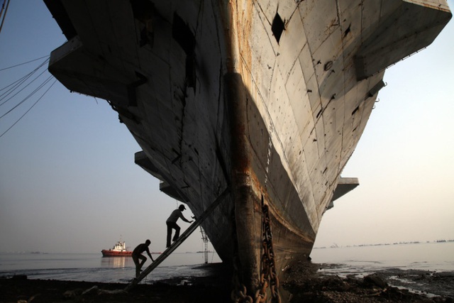 Công nhân trèo thang lên tàu sân bay INS Vikrant tại một xưởng phá dỡ tàu ở Mumbai. Tàu sân bay đầu tiên của Ấn Độ được mua từ Anh vào năm 1957 và dừng hoạt động năm 1997.