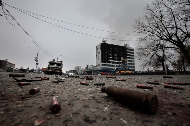 Nhiều vỏ đạn và một chiếc xe ô tô bị phá hủy nằm trên quảng trường bên ngoài tòa nhà bị những kẻ khủng bố tấn công ở Grozny, Nga.