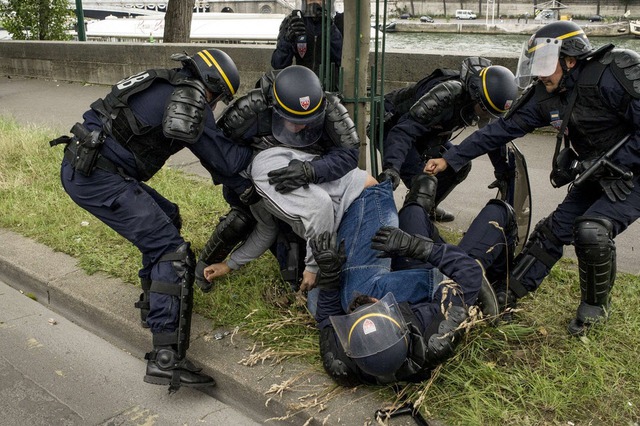 Cảnh sát chống bạo động bắt giữ một công nhân của công ty tàu điều hành đường sắt SNCF trong cuộc đình công ở Paris, Pháp.