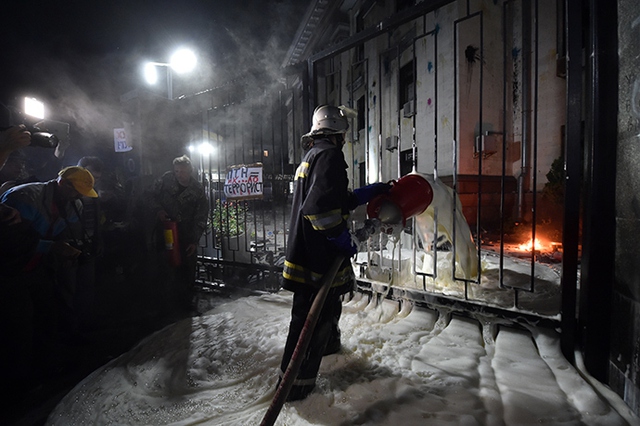 Nhân viên cứu hoả dập tắt lửa bên trong sân Đại sứ quán Nga.