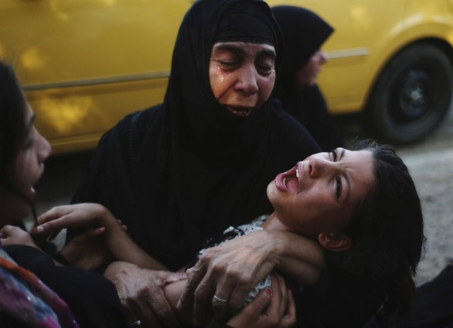 Những người phụ nữ than khóc một dân nhân theo đảo Hồi dòng Sunni bị các chiến binh Hồi giáo dòng Shiite hành hình ở ngoại ô thành phố Baghdad, Iraq.