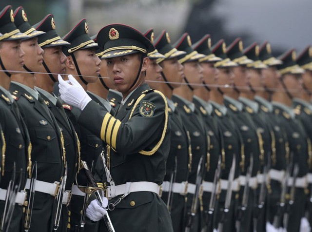 Sĩ quan quân đội Trung Quốc dùng một sợi dây để đảm bảo các thành viên của đội tiêu binh danh dự đứng thẳng hàng trước lễ đón Thủ tướng Đức Angela Merkel tới thăm Bắc Kinh.