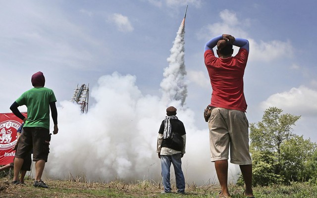 Mọi người theo dõi rocket tự chế được phóng lên không trung tại lễ hội Bun Bang Fai ở Yasothon, Thái Lan.