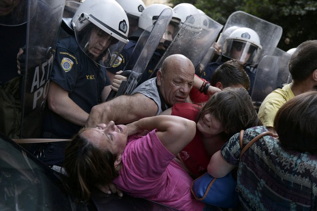 Cảnh sát chống bạo động đẩy lui những người biểu tình trước tòa nhà của Bộ Tài chính Hi Lạp ở Athens.