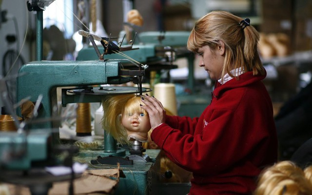 Công nhân đang may tóc cho búp bê tại một nhà máy sản xuất đồ chơi trẻ em ở Buenos Aires, Argentina.