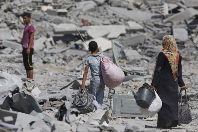 Những người Palestine thu lượn đồ của họ từ những căn nhà bị phá hủy trong cuộc không kích của Israel nhằm thị trấn Beit Hanoun, Dải Gaza.