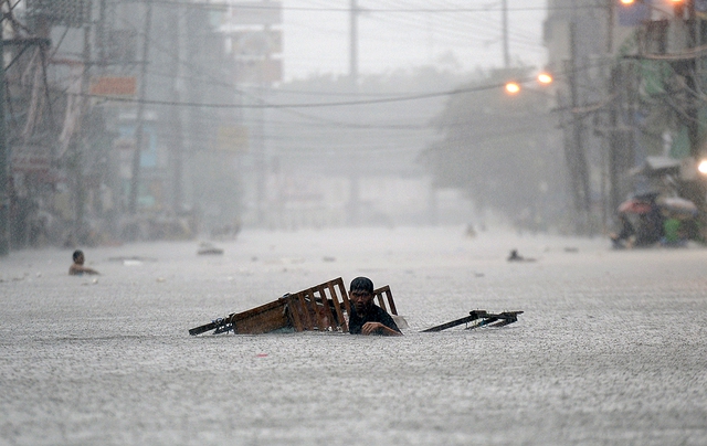 Người dân cố gắng sơ tán khỏi khu vực ngập lụt ở thủ đô Manila, Philippines.