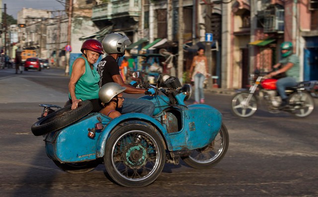 Mọi người đi trên chiếc mô tô ba bánh do Liên Xô cũ sản xuất ở Havana, Cuba.