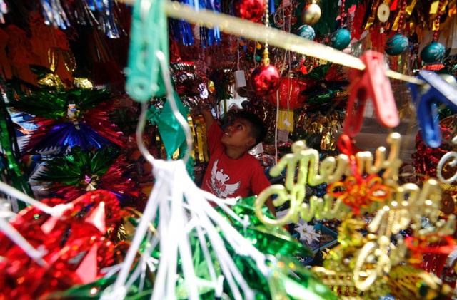 John Michael Orivia, 13 tuổi, sắp xếp đồ Giáng sinh tại cửa hàng ở Manila, Philippines. Người dân nước này tận hưởng lễ Giáng sinh dài nhất thế giới, bắt đầu từ đầu tháng 9 hàng năm.
