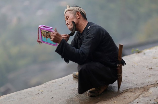 Một người đàn ông dân tộc Miao dùng liềm để cạo râu tại ngôi làng Basha, tỉnh Quý Châu, Trung Quốc.