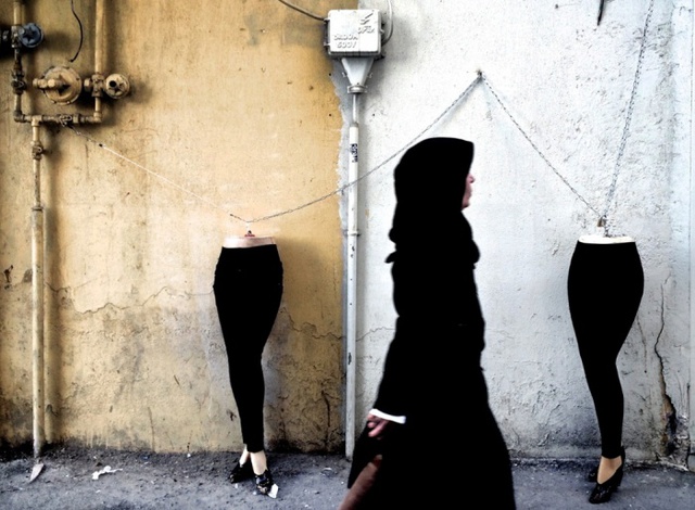 Người phụ nữ đi qua các manơcanh được khóa vào đường ống ga ở Tehran, Iran.