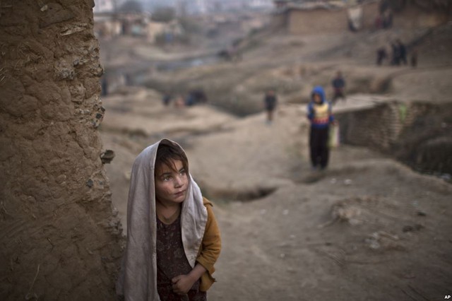 Bé gái người Afghanistan đứng cạnh cửa ngôi nhà xây bằng bùn tại một khu dân cư nghèo ở Islamabad, Pakistan.