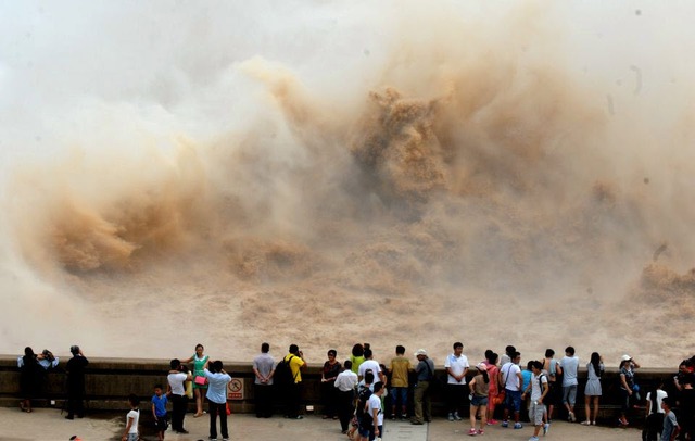 Khách du lịch chiêm ngưỡng cảnh xả bùn tại đập Xiaolangdi trên sông Hoàng Hà ở Tế Nguyên, Trung Quốc.