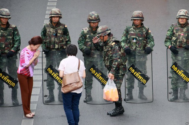 Người dân tặng đồ uống lạnh cho các binh sĩ bảo vệ khu vực quanh đài tưởng niểm Chiến thắng ở Bangkok, Thái Lan.