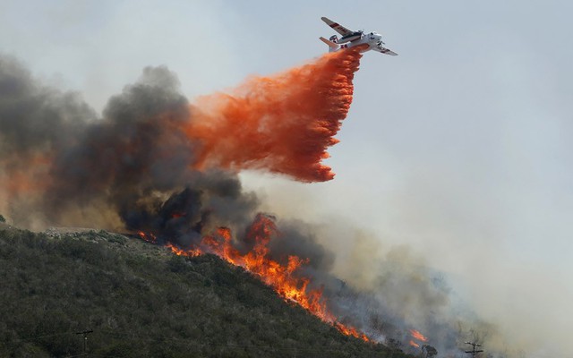 Một chiếc máy bay thả hóa chất ngăn cháy để dập tắt cháy rừng gần San Marcos, California, Mỹ.