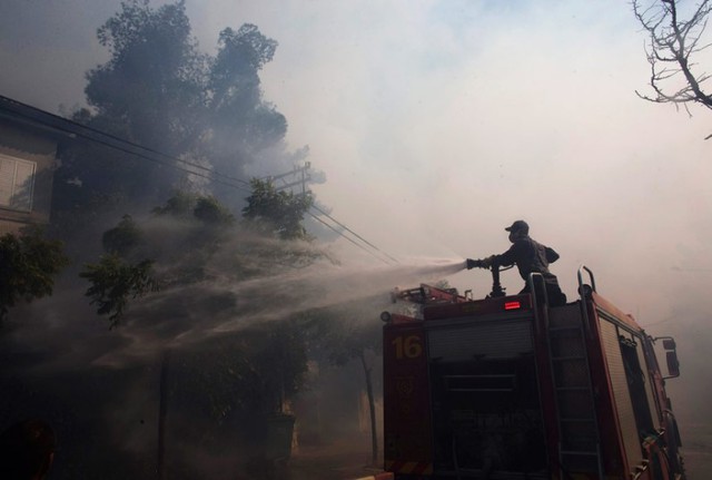 Lính cứu hỏa Israel phun nước vào một ngôi nhà trong khi chữa cháy rừng ở Jerusalem.