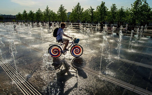 Một thiếu niên đạp xe trên đài phun nước khi nhiệt độ tăng cao ở Moscow, Nga.