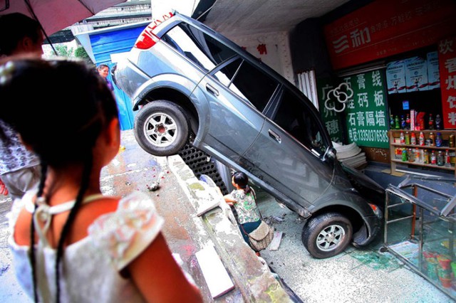 Chiếc ô tô lao khỏi bãi xe và đâm vào một cửa hàng ở phía dưới tại thành phố Trùng Khánh, Trung Quốc.