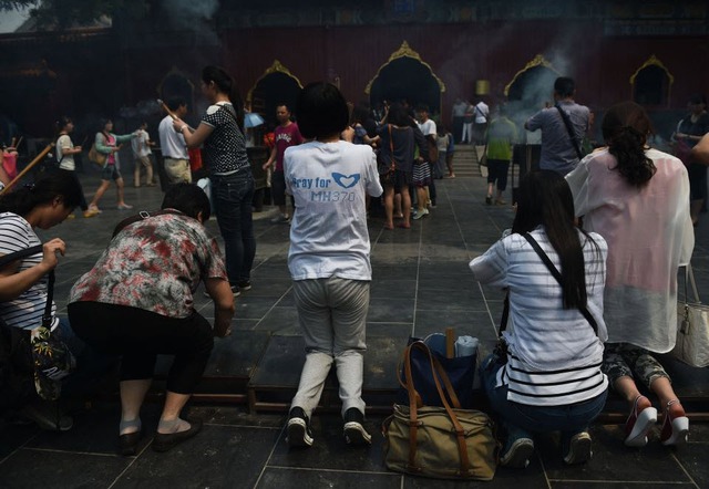 Thân nhân cầu nguyện cho hành khách trên chuyến bay MH370 của hãng hàng không Malaysia Airlines tại một ngôi chùa ở Bắc Kinh, Trung Quốc, 100 ngày sau khi máy bay này mất tích.