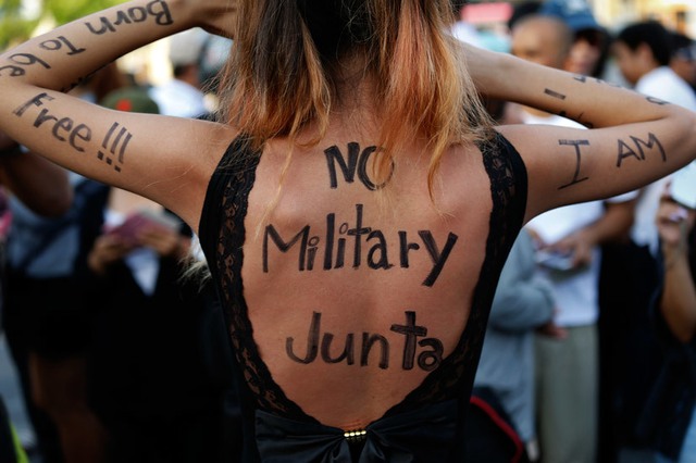 Một phụ nữ với thông điệp được viết trên lưng tham gia biểu tình phản đối quân đội đảo chính ở Bangkok, Thái Lan.