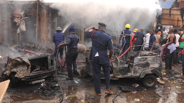 Lính cứu hỏa nỗ lực dập tắt lửa tại hiện trường vụ đánh bom tại khu chợ Terminus ở thành phố Jos, Nigeria, khiến ít nhất 118 người thiệt mạng.