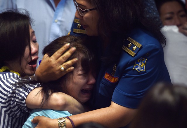 Bầu không khí tang thương và hoảng loạn khi những hình ảnh vớt thi thể nạn nhân trên chuyến bay QZ8501 được phát trên TV One.