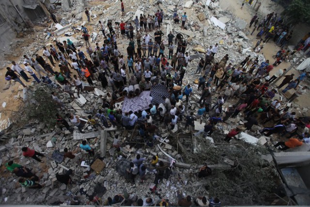 Người dân Palestine tìm kiếm trong đống đổ nát của ngôi nhà bị phá hủy bởi quân đội Israel ở Al Sheikh Redwan, thành phố Gaza.