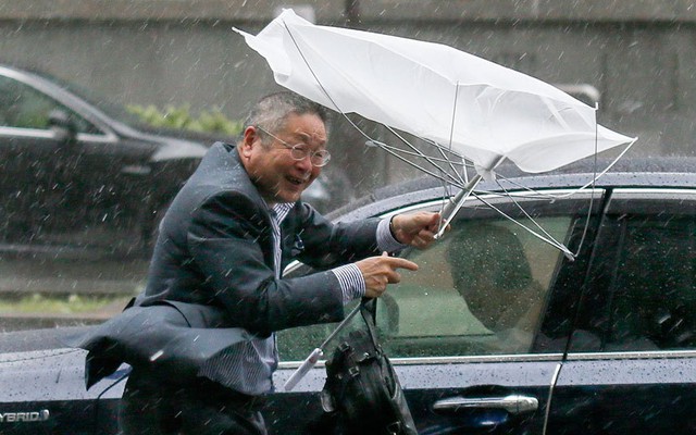 Một thương nhân vất vả giữ ô trong gió và mưa lớn gây ra bởi bão Phanfone ở Tokyo, Nhật Bản.