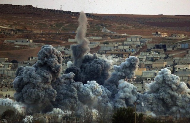 Cột khói bụi lớn bốc lên cao rồi bao trùm thị trấn chiến lược Kobani ở Syria, sau một đợt không kích của liên quân quốc tế nhằm vào phiến quân Nhà nước Hồi giáo.