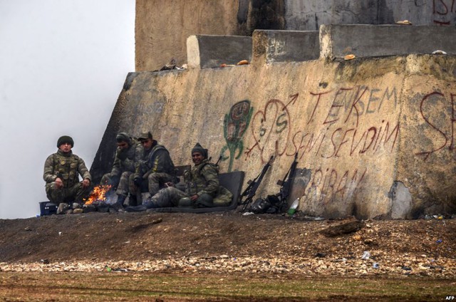 Các binh sĩ Thổ Nhĩ Kỳ sưởi ấm quanh một đống lửa tại thị trấn Mursitpinar thuộc tỉnh Sanliurfa, giáp biên giới với Syria.