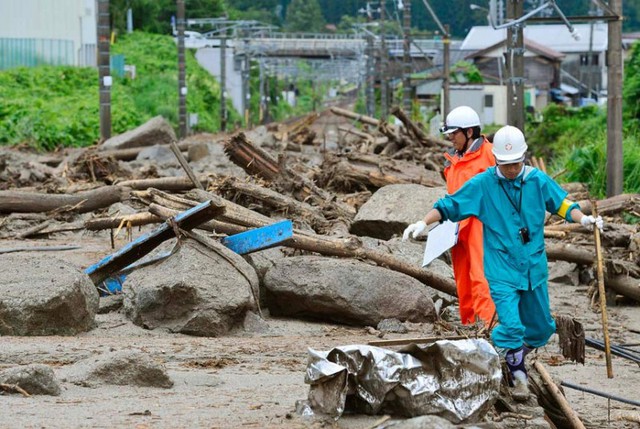 Nhân viên cứu hộ đi qua hiện trường vụ lở đất do siêu bão Neoguri gây mưa lớn tại Nagiso, Nhật Bản.