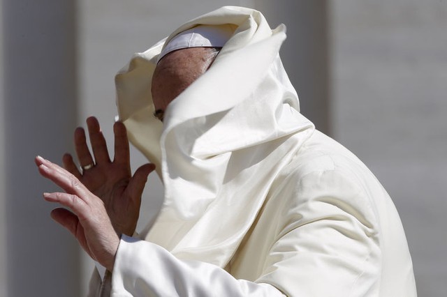 Gió thổi bay mũ áo choàng của Giáo hoàng Francis khi ông tới diễn thuyết tại quảng trường Saint Peter ở Vatican.